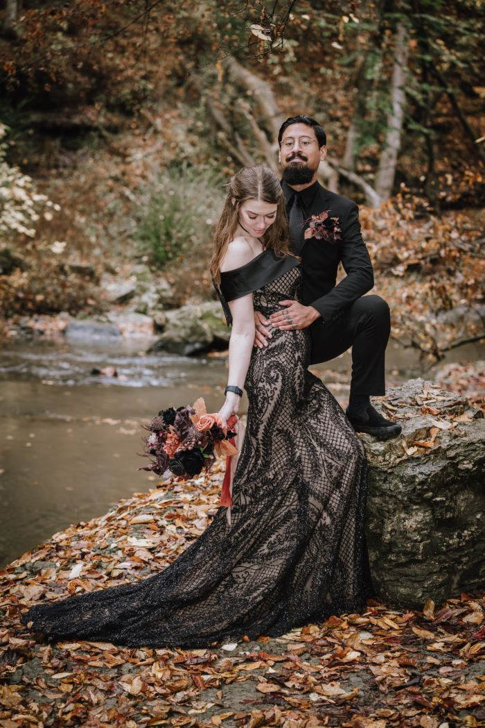 Couple in autumn by a Tennessee creek, bride in a black gown