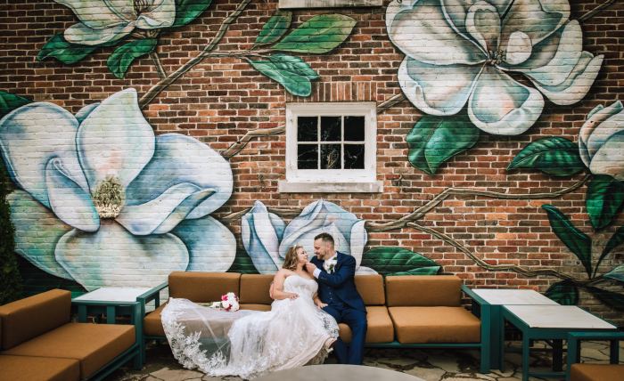 Couple beside a painted magnolia mural in downtown Nashville