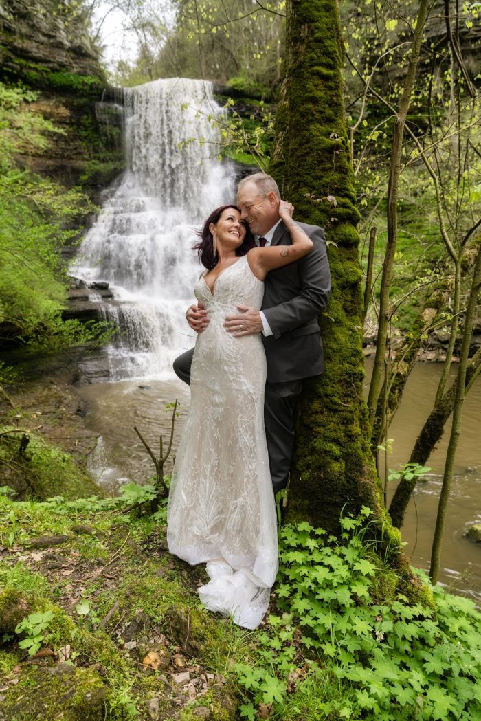 Couple embrace before a private Tennessee waterfall