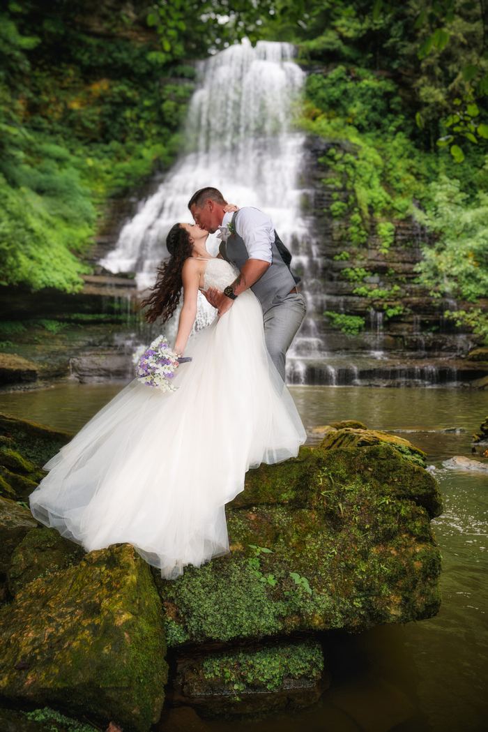 Couple kiss on the rocks before a Tennessee waterfall