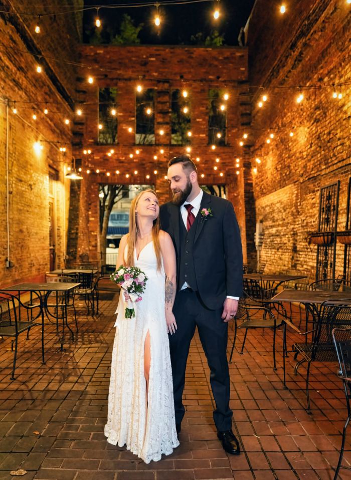 Couple at a warm string-lit rustic venue in Nashville