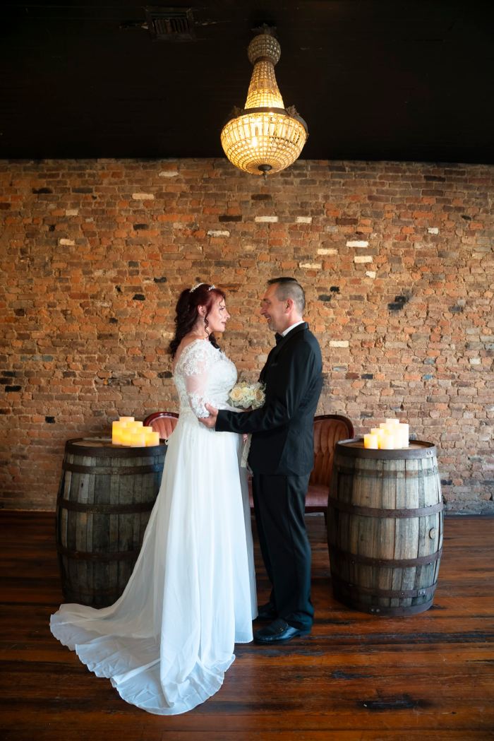 Couple by wine barrels and pumpkins at an autumn Nashville elopement